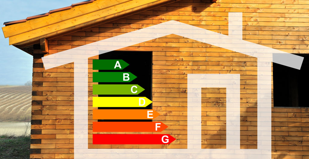 Des mains tiennent un plan de rénovation et des échantillons de matériaux devant un mur en pierre brute d'un chalet ancien